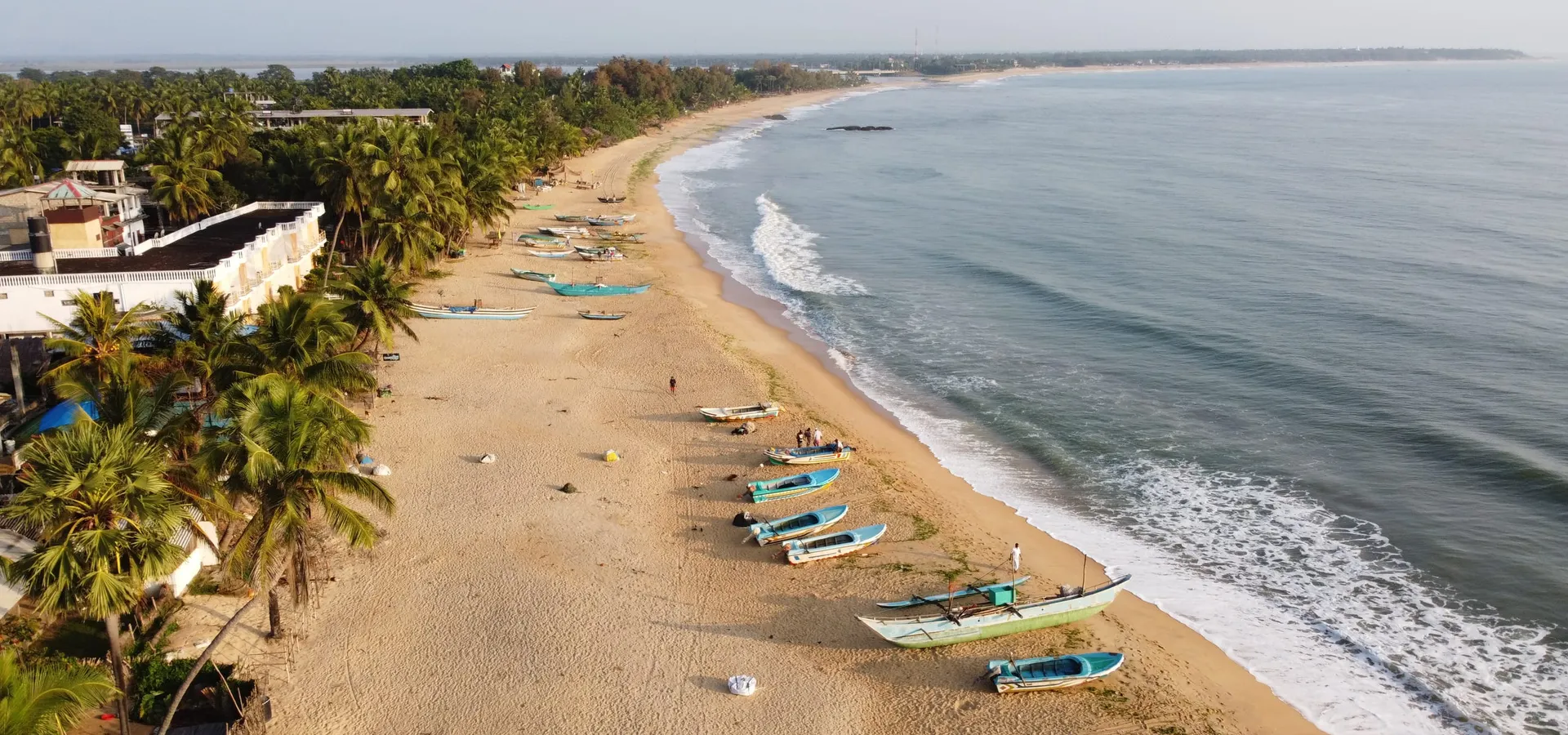 Fishing boats on the curve of Arugam Bay from above