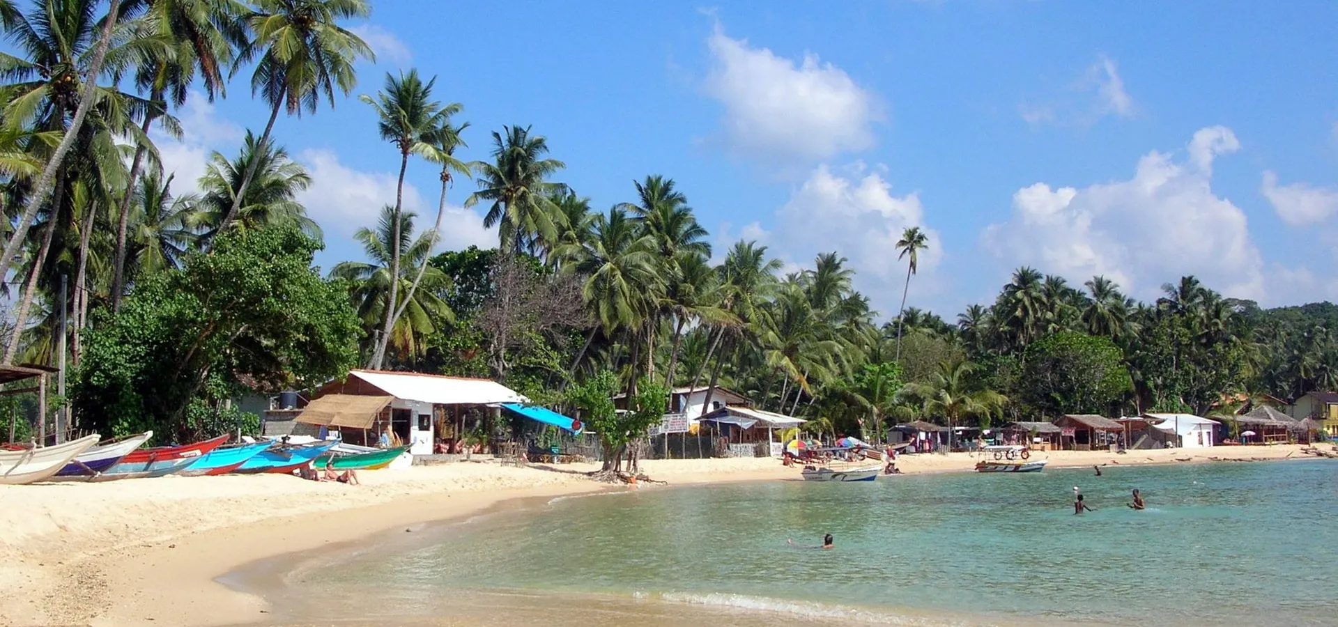 The sheltered swimming bay of Unawatuna fringed with palms